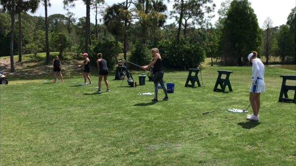 A group of people playing frisbee golf in the park.